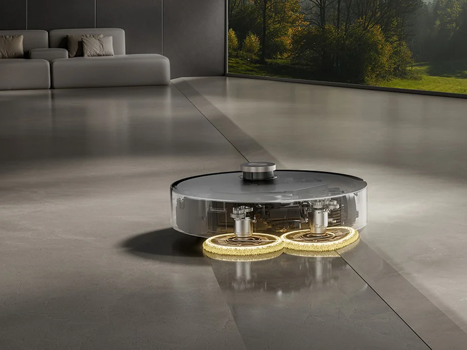 Прозорий корпус робота-прибиральника демонструє роботу внутрішніх механізмів миття підлоги.