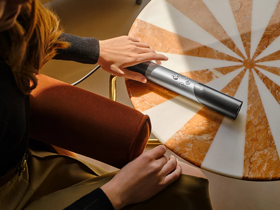 Жінка кладе перукарню на круглий стіл з візерунком у вигляді мармурових променів.