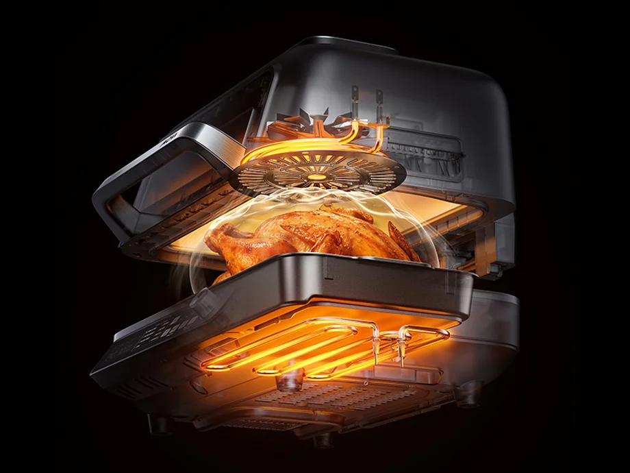 Поперечний розріз підсвіченого кухонного приладу з куркою, що смажиться всередині, що показує роботу нагрівальних елементів.