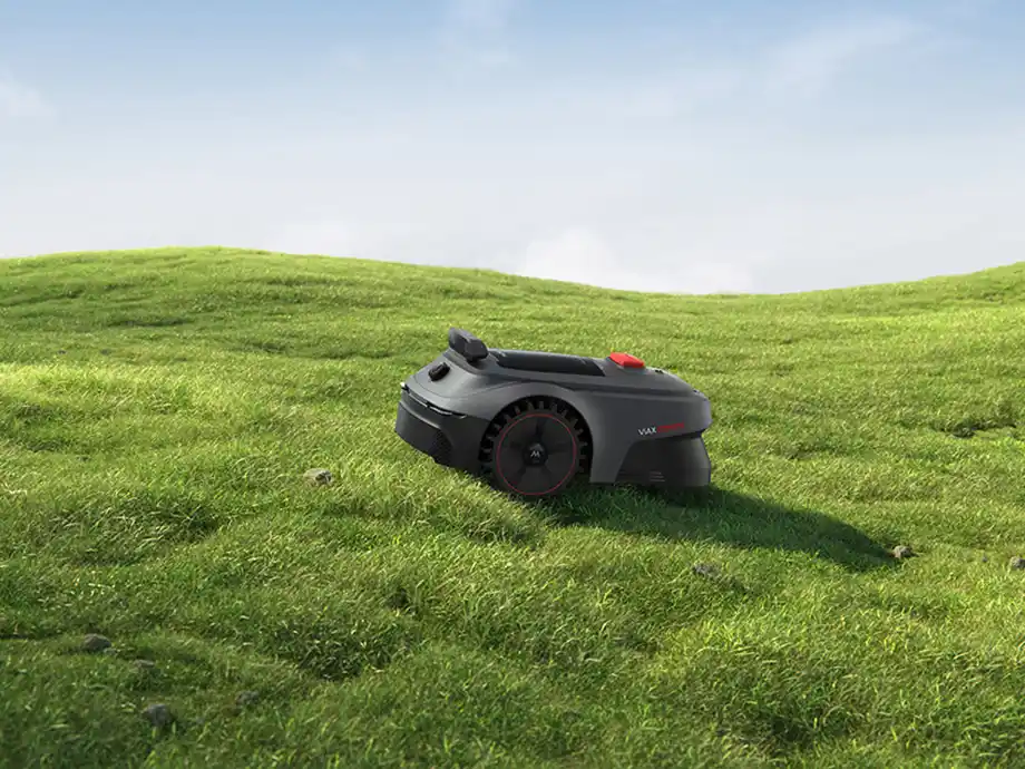 Робот-косарка працює на горбистій місцевості, вкритій травою.