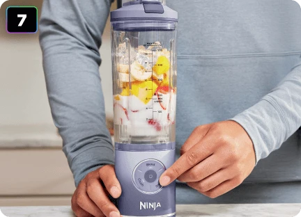 Чоловічі руки з вказівним пальцем на кнопці налаштувань блендера Ninja Blast Max BC251EU