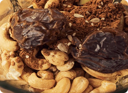 Крупний план інгредієнтів усередині блендера: інжир, кешью, какао-порошок