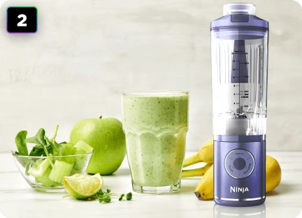 Блендер Ninja Blast Max BC251EU на кухонному столі поруч із зеленим напоєм, бананом, яблуком та лаймом