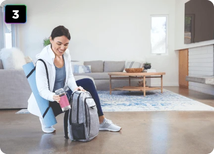 Жінка кладе блендер Ninja Blast Max BC251EU у свій рюкзак.