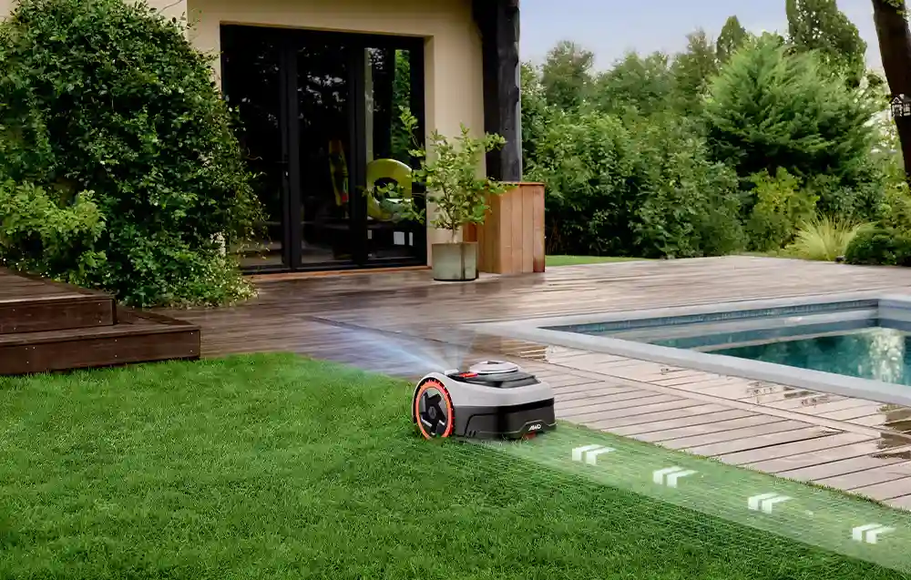 роботи косять газон вздовж бруківки біля басейну, перед будинком