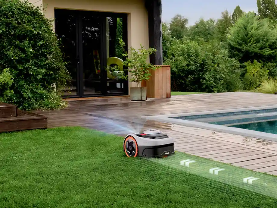 роботи косять газон вздовж бруківки біля басейну, перед будинком