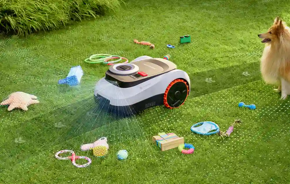 робот косить траву, навколо нього розкидані іграшки, а поруч стоїть собака