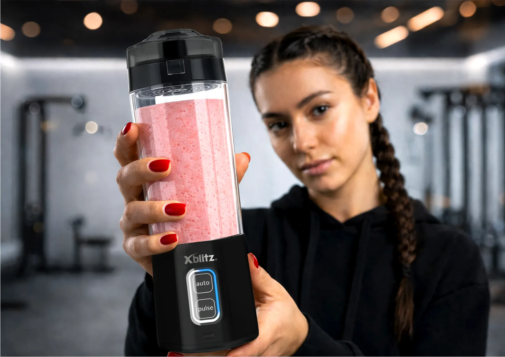 Kobieta trzyma blender z różowym koktajlem, zbliżenie na urządzenie Xblitz i przyciski sterowania