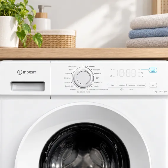 Zbliżenie na panel sterowania pralki Indesit z pokrętłem wyboru programów, wyświetlaczem i przyciskami.
